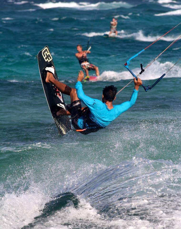 Kitesurfer riding a wave off Boca Grandi beach